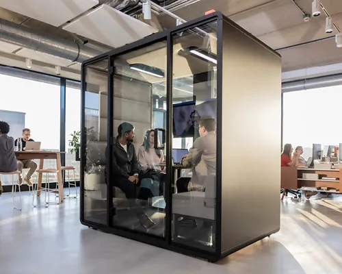 Cabine acoustique Hush installée dans un bureau moderne pendant une discussion d’équipe.