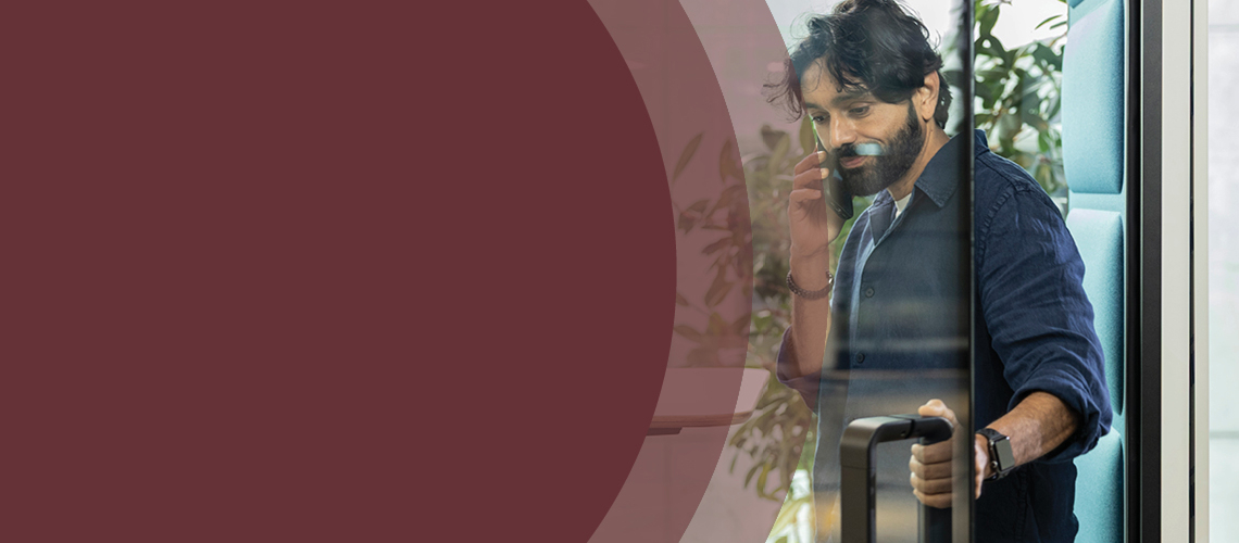 Person using a Hush acoustic phone booth in an office setting.