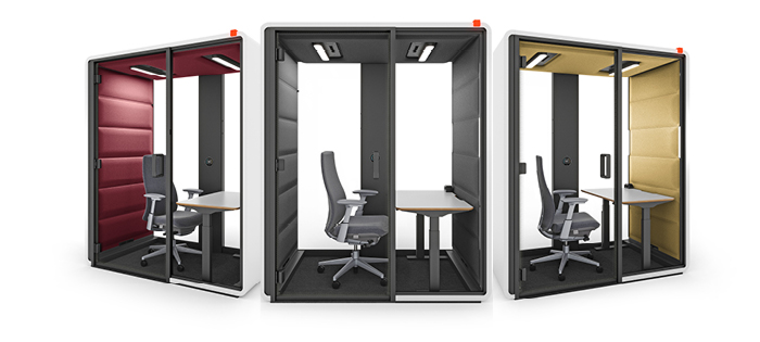 Osoba pracująca w kabinie Hushfree Work przy dużym monitorze z arkuszem danych.