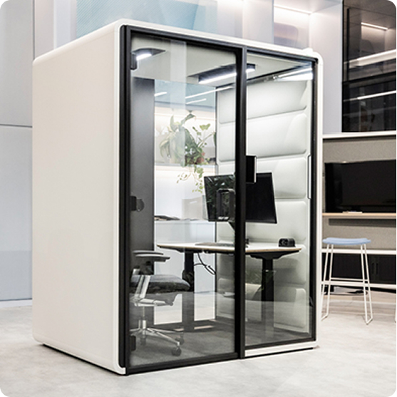 Kabina akustyczna Hushfree Work podczas wideokonferencji, z monitorem wyświetlającym rozmowę.