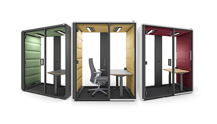 Osoba pracująca w kabinie Hushfree Work przy dużym monitorze z arkuszem danych.